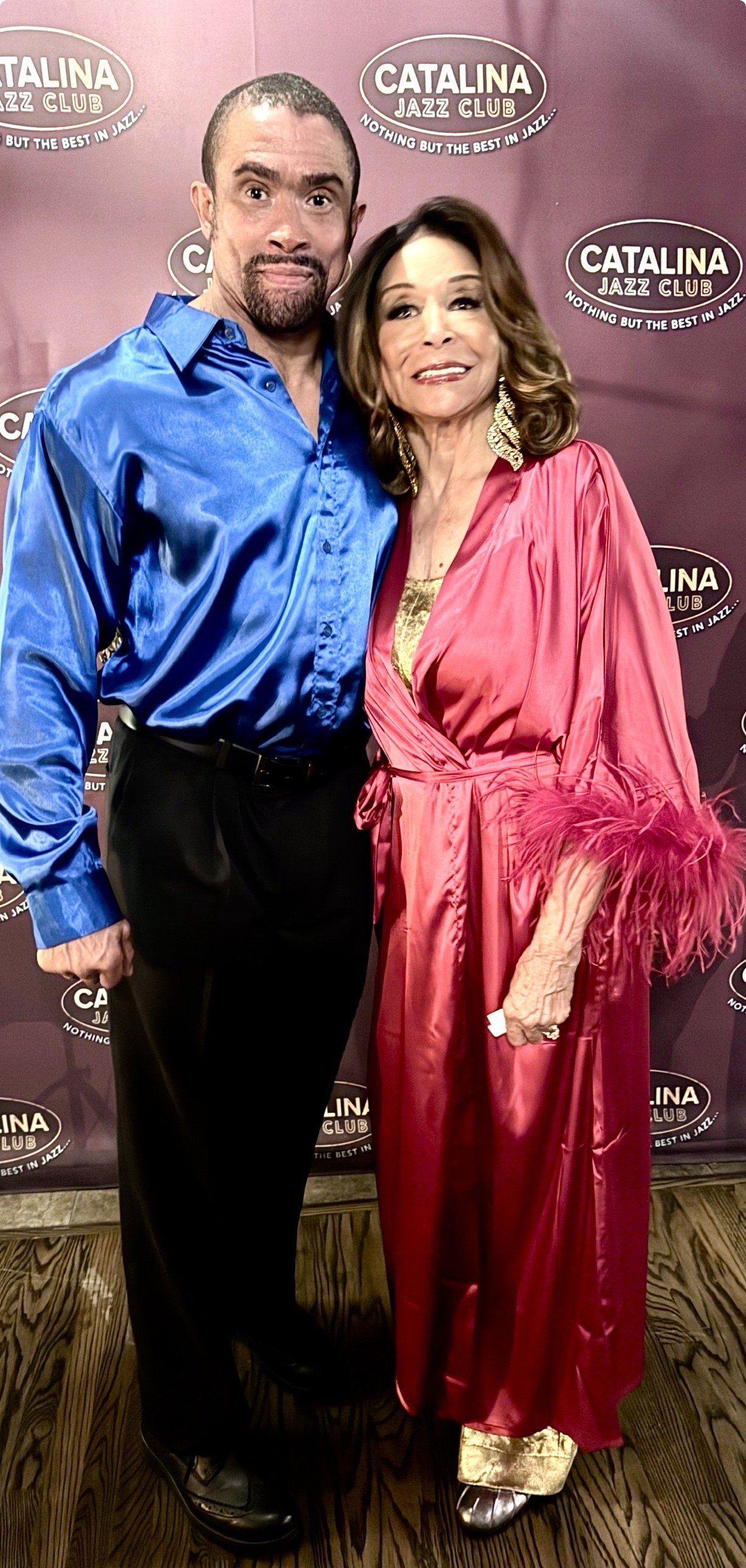 Freda Payne in a rose satin robe with feather cuffs alongside her son Gregory Abbott Jr. at the Catalina Jazz Club step and repeat